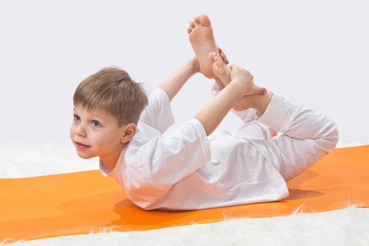 Children's yoga. The little boy does exercise. 