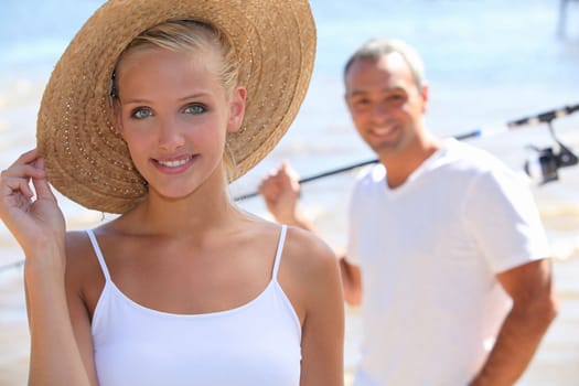 pretty blonde with sun hat and boyfriend in background