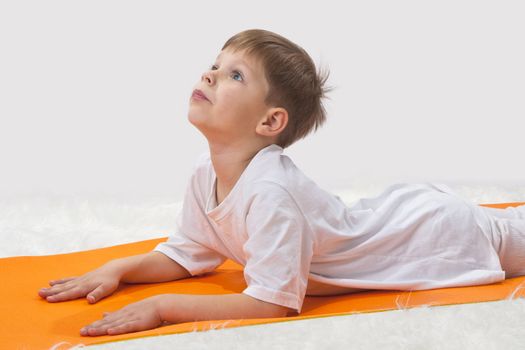 Children's yoga. The little boy does exercise. 