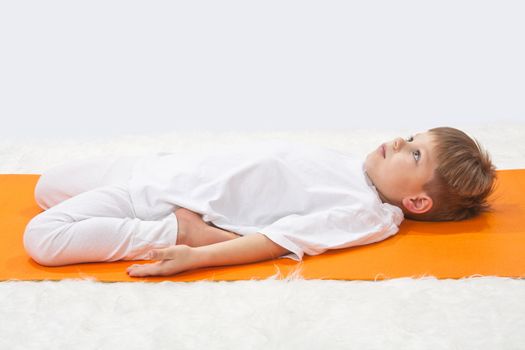 Children's yoga. The little boy does exercise. 