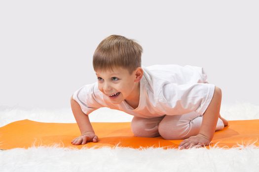 Children's yoga. The little boy does exercise. 