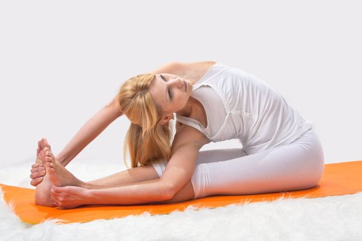 Young beautiful girl is professionally engaged in yoga 