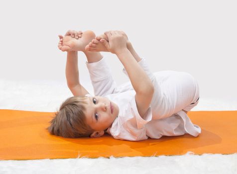 Children's yoga. The little boy does exercise.