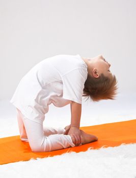 Children's yoga. The little boy does exercise.