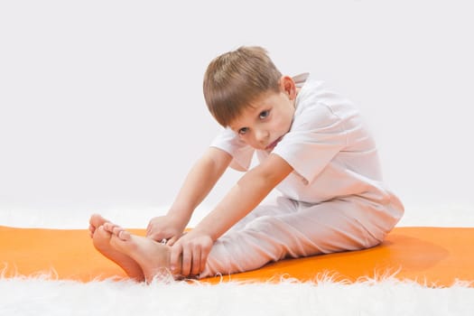 Children's yoga. The little boy does exercise. 