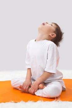 Children's yoga. The little boy does exercise. 