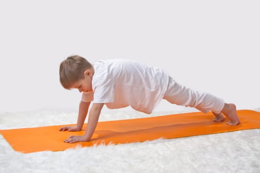 Children's yoga. The little boy does exercise. 