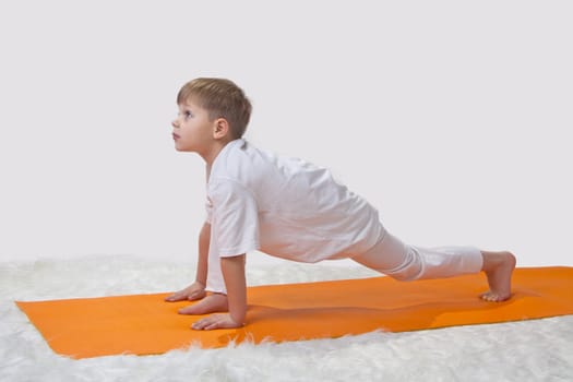 Children's yoga. The little boy does exercise. 