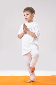 Children's yoga. The little boy does exercise. 