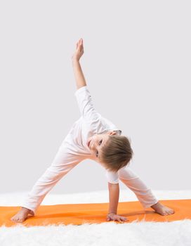 Children's yoga. The little boy does exercise. 