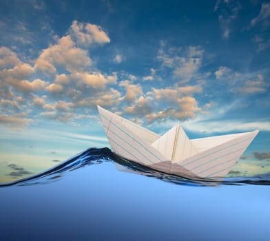 White paper boat floating in the sea.