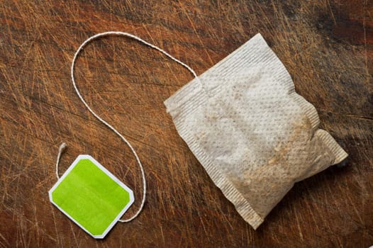 Tea bag on wooden table.