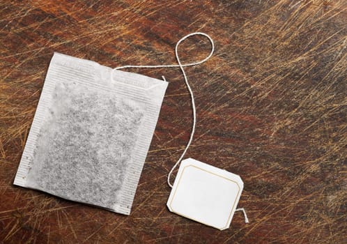 Tea bag on wooden table.