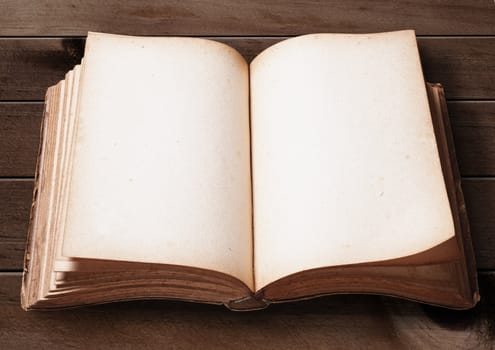 Open Vintage book on wooden table.