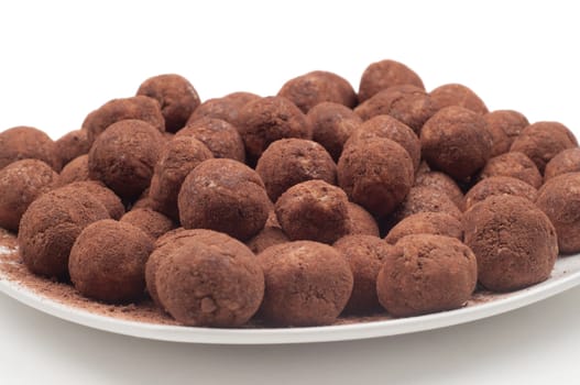 Chocolate truffles on the plate on light background