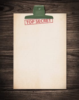 Top secret document on old wooden table.