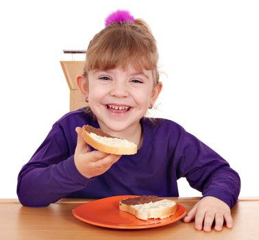 happy little girl eats bread with chocolate