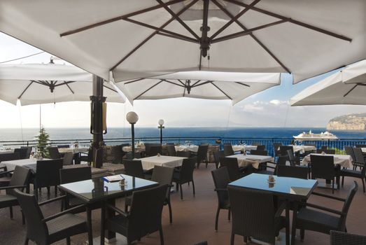 under  umbrellas at restaurant looking across to versuvius and cruise ship, Italy