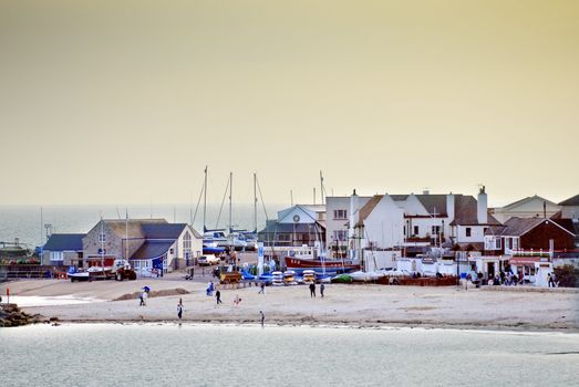 lyme regis beach at sunset with ship masts in background