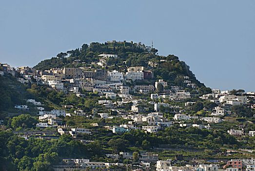 houses stacked close together on big rugged cliffs, capri italy