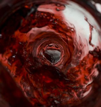 Wine pouring in a glass captured from unusual POV inside the bottle stock photo