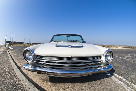 1960's convertible in car park wide angle powerful grill