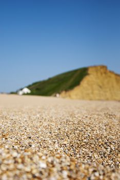 pebbled chesil beach with golden cap in background