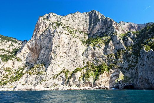 sheer cliffs of capri falling into turqoise mediterannean  sea, italy