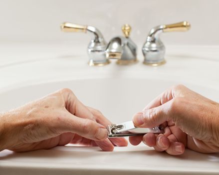 Finger nail clippings in palm of hand on bathroom sink