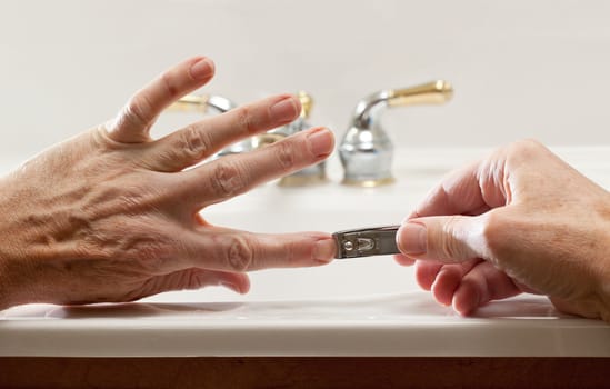 Finger nail clippings in palm of hand on bathroom sink
