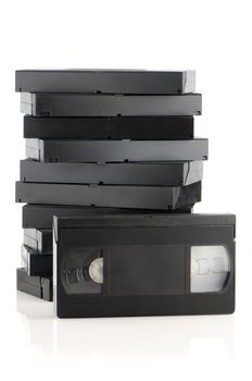 Pile of videotapes on  white reflective background.