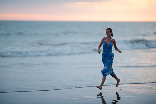 Young beautiful running on a beach.  Coast Pacific ocean in Costa Rica.