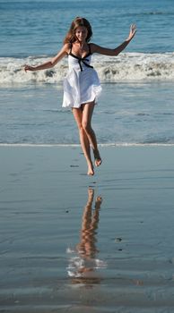 Young beautiful jumping  on a beach.  Coast Pacific ocean in Costa Rica.