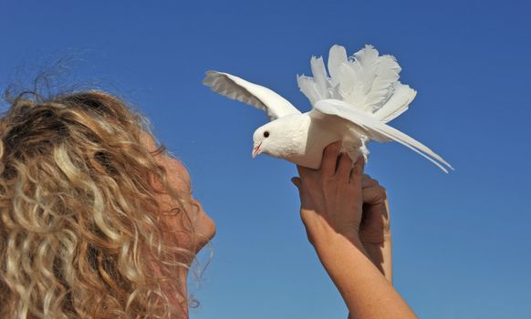 young girl and her dove on a blue sky