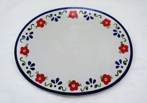 Hand Drawn Ceramic Tile with flower motif on white cement background.