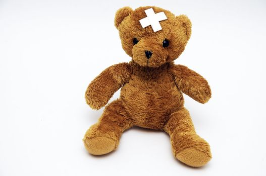 A teddy bear with a sticking plaster on header