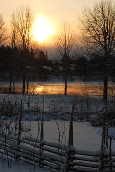 The sun rises behind clouds an early winter day