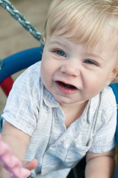 Cute little boy sitting on a swing