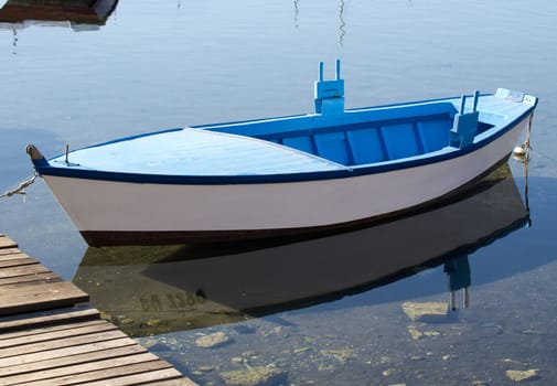 old blue wooden boat parked on the dock