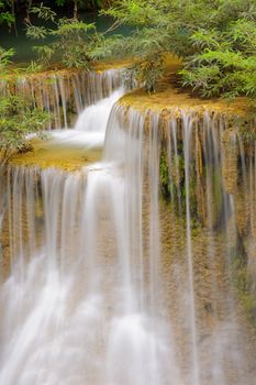 Detail of cascade falls over mossy rocks in rainforest, Thailand.