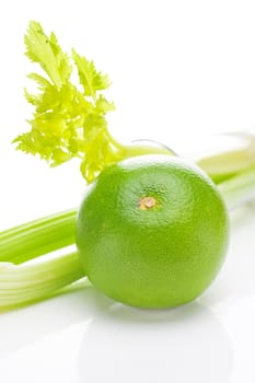 celery in a tall glass, green grapefruit and measure tape isolated on white