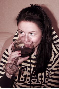 A young, beautiful woman with a glass of red wine