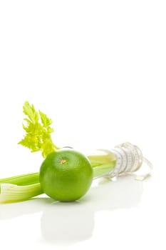 celery in a tall glass, green grapefruit and measure tape isolated on white