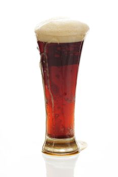 dark beer with the foam in a tall glass isolated on white