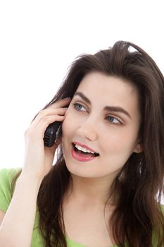 Natural head and shoulders portrait of an attractive brunette woman talking on her mobile phone isolated on white