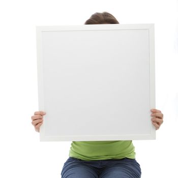 Unrecognized woman covering her face using a blank white board