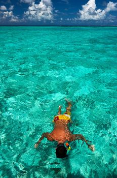 Man snorkeling in crystal clear turquoise water at tropical beach