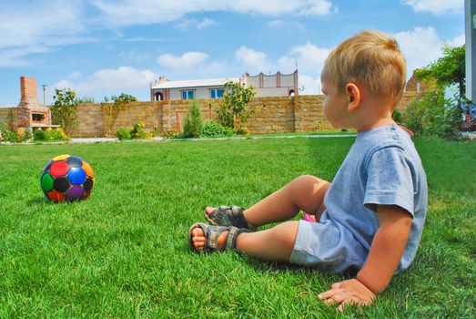 The kid with the ball on the grass