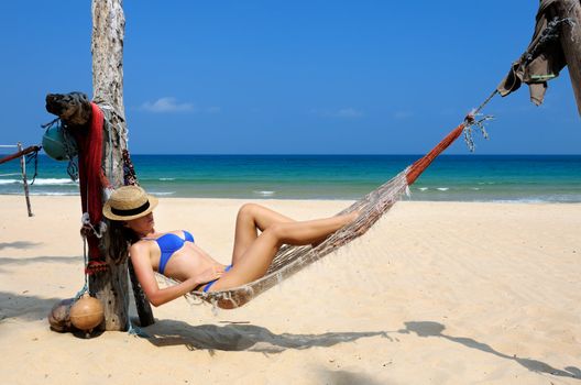 Woman in hammock on tropical beach at Tioman island, Malaysia