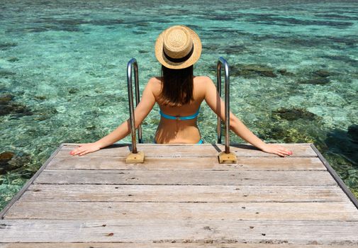 Woman on a tropical beach jetty at Maldives